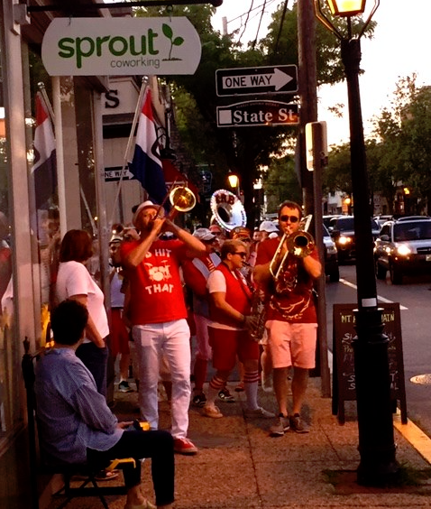 Sprout CoWorking Warren. The Extraordinary Rendition Band plays in a procession just outside on Main Street.
